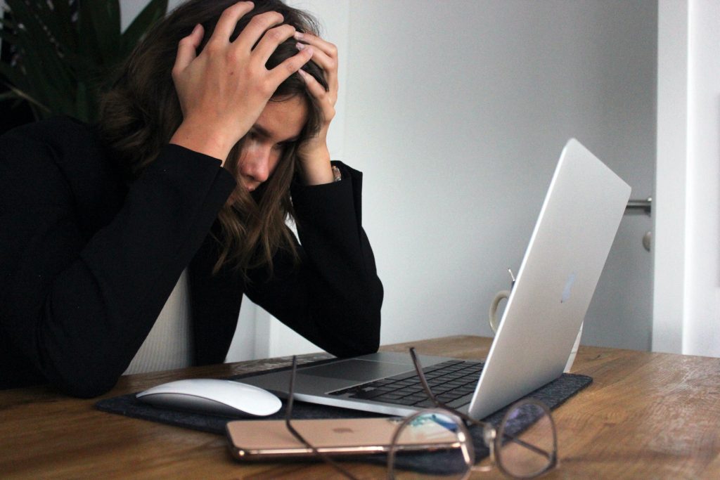 Woman looking at computer screen, looking despondent